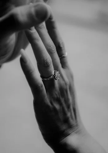Close-up of a couple’s hands gently touching, highlighting an engagement ring during a Barcelona photoshoot.