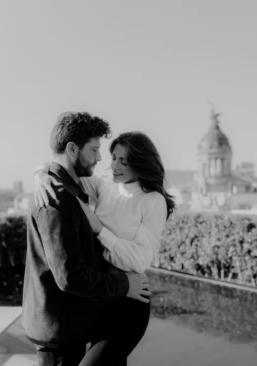 Couple embracing on a rooftop in Barcelona, sharing a joyful moment during an engagement photography session.