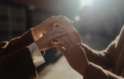 Couple gently holding hands in warm sunlight during an engagement photoshoot in Barcelona.