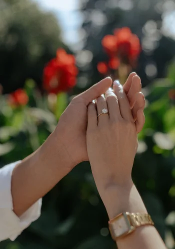 Couple holding hands after a surprise proposal in Barcelona, showing an engagement ring and joyful emotion.
