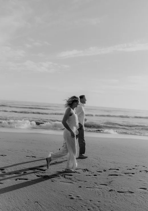 Couple joyfully running along the Barcelona beach, captured during a surprise proposal photoshoot.
