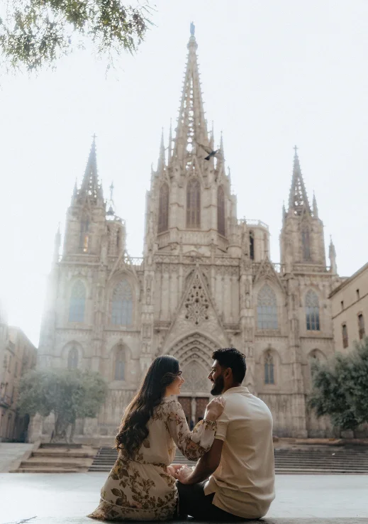 Couple sharing a joyful moment in front of Barcelona Cathedral, captured during an engagement photo session.