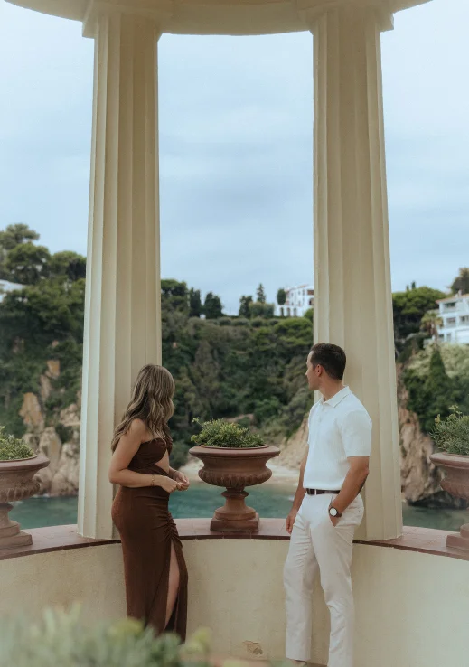 Couple sharing a quiet moment during a surprise proposal photoshoot in a scenic Barcelona pavilion.