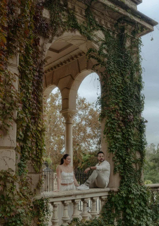 Couple sharing a quiet moment on a vine-covered terrace in Barcelona, captured during an engagement photoshoot.