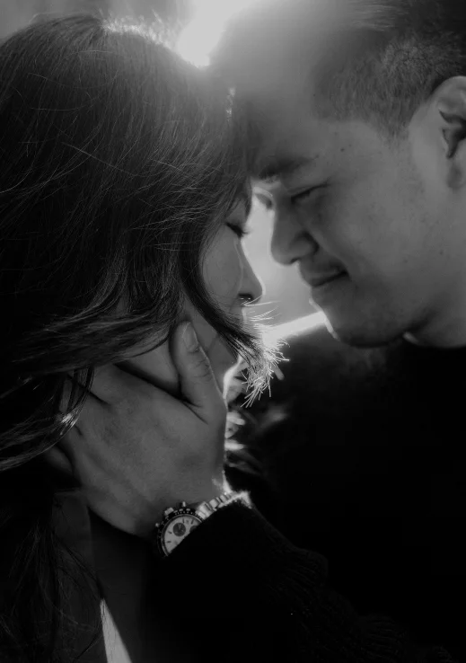 Couple sharing an intimate moment during a Vacation Portraits photoshoot in Barcelona, sunlight softly illuminating them.