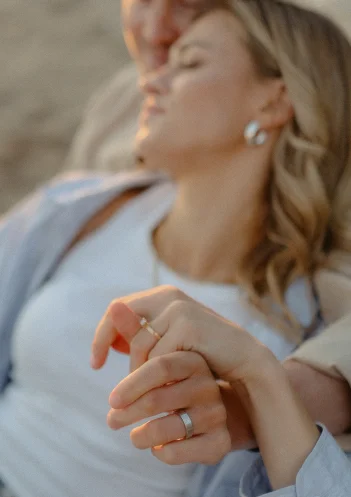 Engaged couple holding hands and relaxing together, captured during a couples photoshoot in Barcelona.