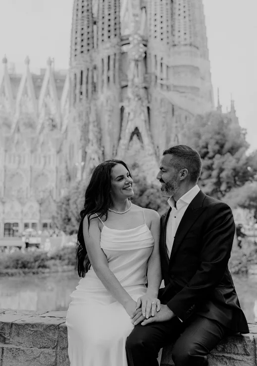 Engaged couple sharing a joyful moment in front of Sagrada Família, Barcelona couples photoshoot.