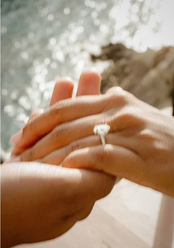 Hands clasped in a romantic surprise proposal photoshoot in Barcelona, sparkling engagement ring in focus.