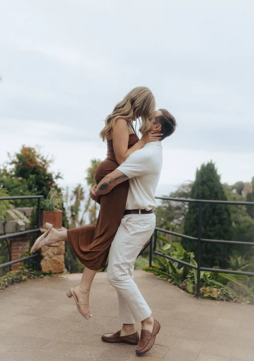 Joyful couple embraces after a surprise proposal in Barcelona, capturing love and excitement in a candid moment.
