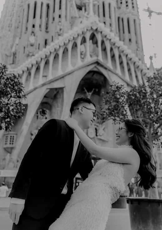 Joyful couple laughing together during a Vacation Portraits photoshoot in front of Sagrada Familia, Barcelona.