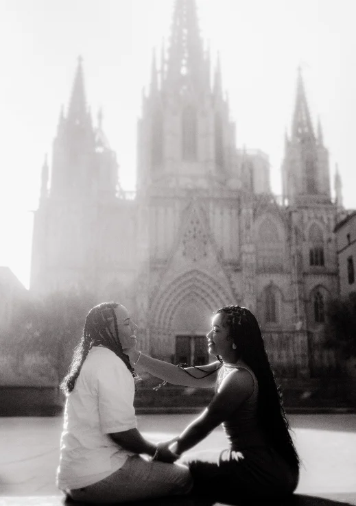 Joyful couple sharing a tender moment during a surprise proposal photoshoot in front of Barcelona Cathedral.