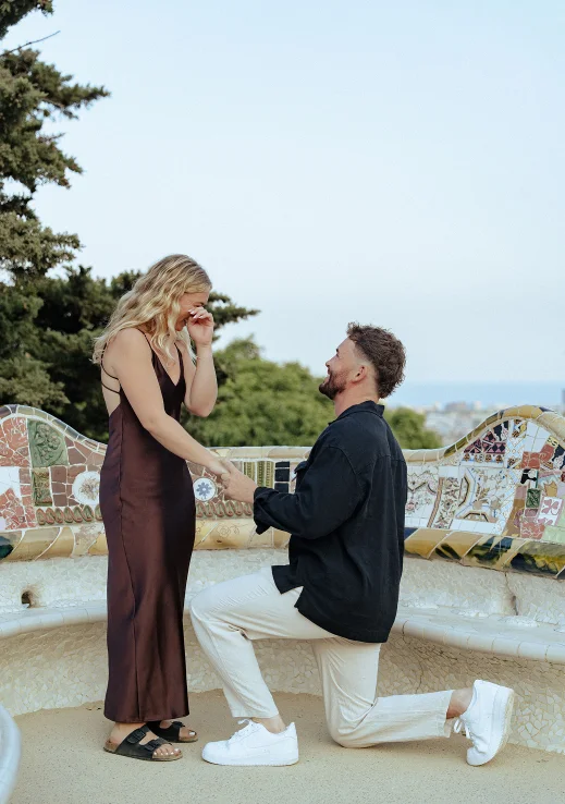 Man proposing to his emotional partner during a surprise proposal photoshoot in Park Güell, Barcelona.