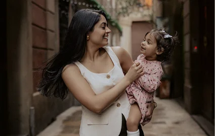 Mother and daughter share a joyful moment during a Vacation Portraits photoshoot in a charming Barcelona alley.