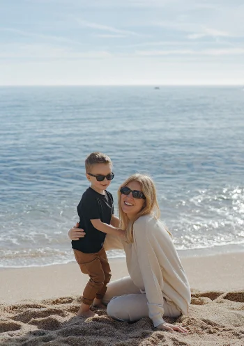 Mother and son share a joyful moment on a sunny Barcelona beach, Vacation Portraits photoshoot.