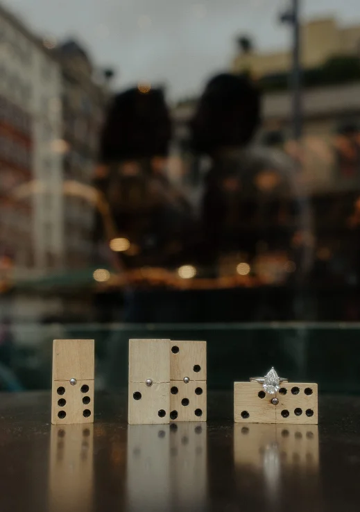 Romantic couple’s silhouette reflected in Barcelona, engagement ring on dominoes for couples photoshoot.