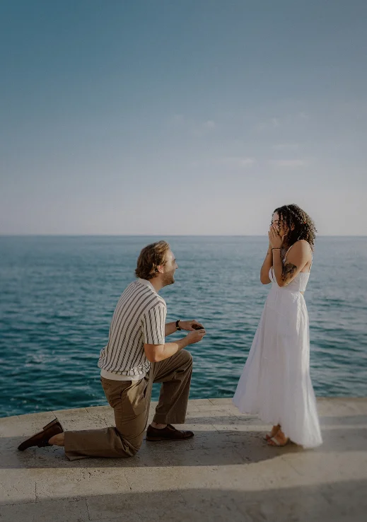 Romantic surprise proposal by the sea in Barcelona, capturing pure joy and emotion during a special moment.