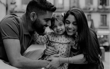 Smiling family embraces their young daughter during a joyful Vacation Portraits photoshoot in Barcelona.