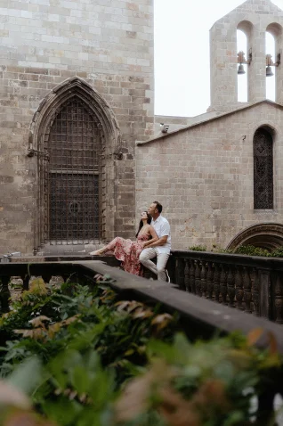 Couple embraces on a historic balcony in Barcelona, captured during a Vacation Portraits photoshoot.