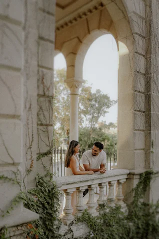 Couple sharing a joyful moment on a sunlit balcony in Barcelona, perfect for engagement photography sessions.