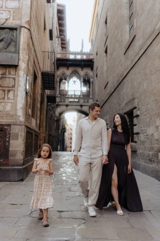 Family enjoying a Vacation Portraits photoshoot, walking together in Barcelona’s Gothic Quarter, sharing smiles and joy.