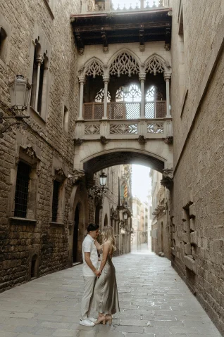 Romantic couple holds hands in a quiet Barcelona street, perfect for an engagement photoshoot session.
