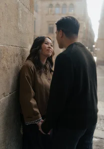 Couple shares a tender moment during a vacation portraits photoshoot in a sunlit European street.