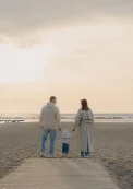 Family walking together on Barcelona beach at sunset during vacation photoshoot