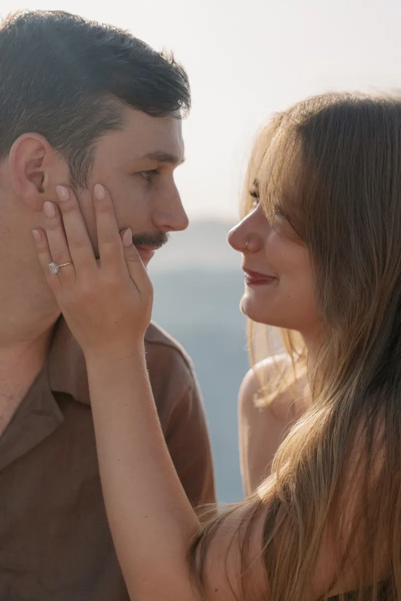 Megan touches Tim’s cheek with her engagement ring visible.