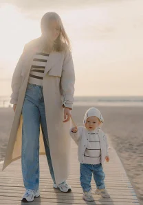 Mother and toddler walking on wooden pier during family photoshoot in Barcelona