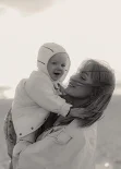 Mother holding baby during family photoshoot on Barcelona beach