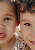 Two smiling children enjoying a sunny day, captured during a vacation portraits photoshoot.